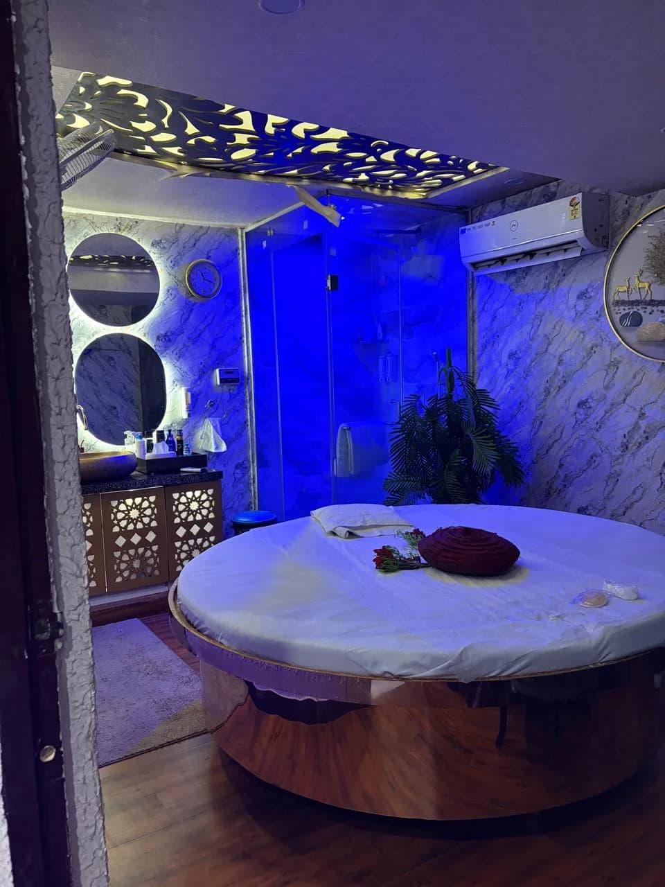 Executive Circular Bed Therapy Room with Ambient Lighting and Glass Shower at Amazing Wellness Spa Lajpat Nagar