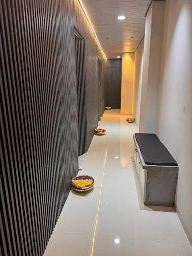 Modern Spa Hallway with Vertical Wooden Slats, Brass Flower Bowls and Soft Floor Lighting