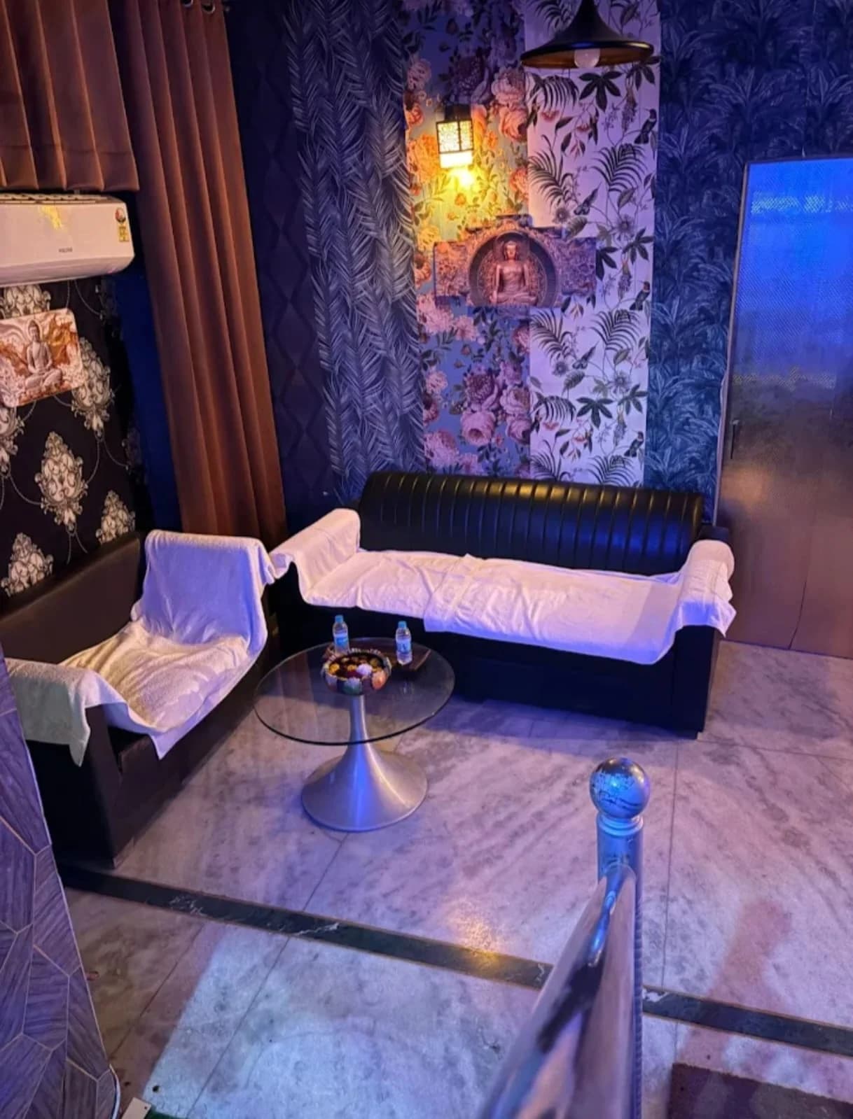 Comfortable Waiting Lounge with Leather Sofas, Marble Table and Buddha Wall Lamp at Amazing Wellness Spa