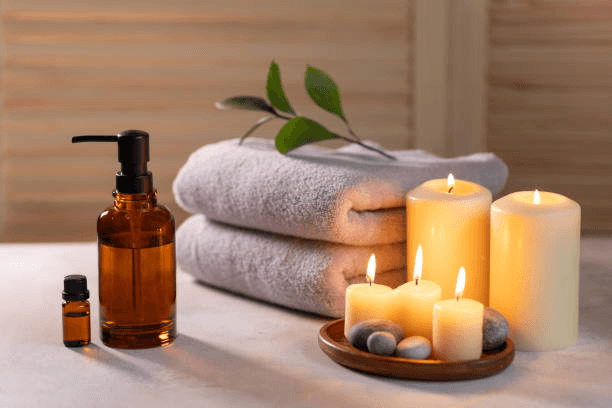 Luxury spa still life with organic towels, river stones, essential oil bottle and glowing candle